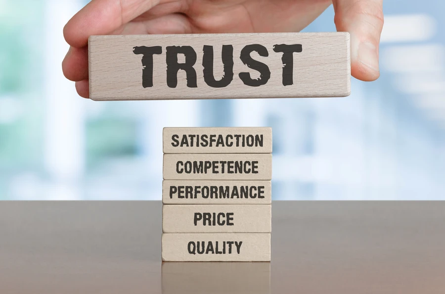 Hand holding block labeled trust