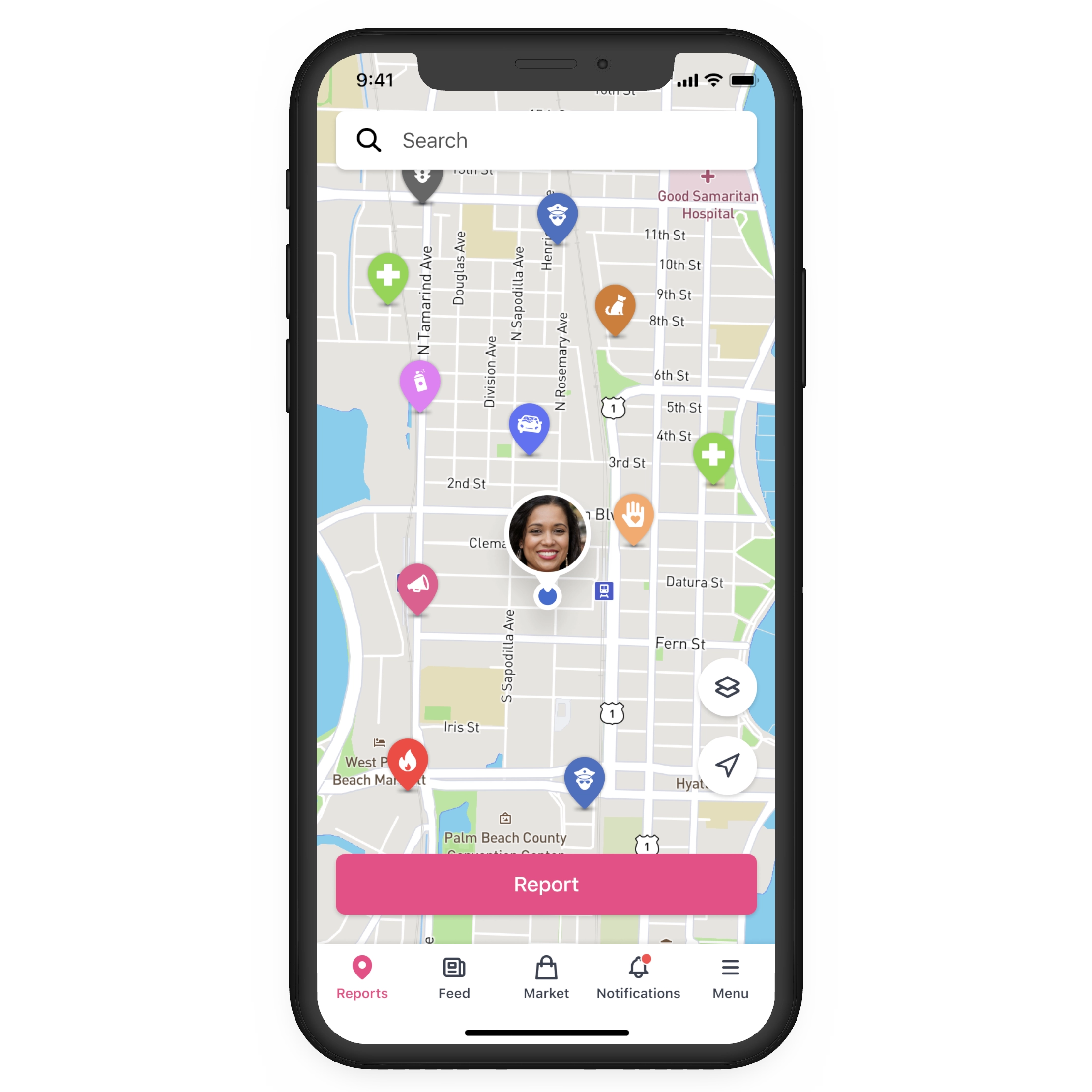 Pantalla de un smartphone en la que se muestra un mapa con marcadores de distintos colores que representan diferentes tipos de avisos y un icono de perfil de usuario en el centro, con un botón rosa de «Avisar» debajo y una barra de navegación en la parte inferior.