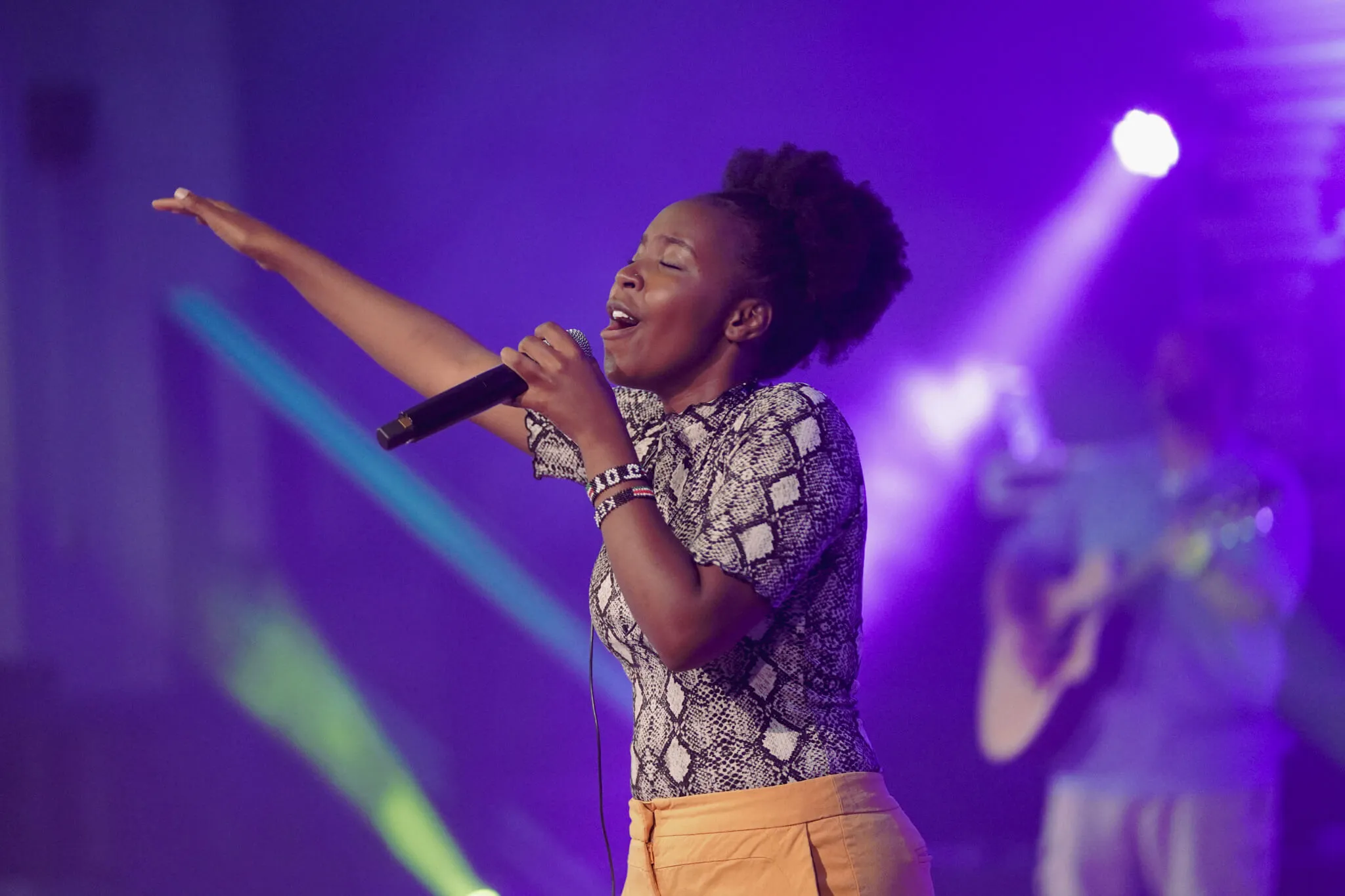 An image depicting a worship leader leading a live worship performance at reach church