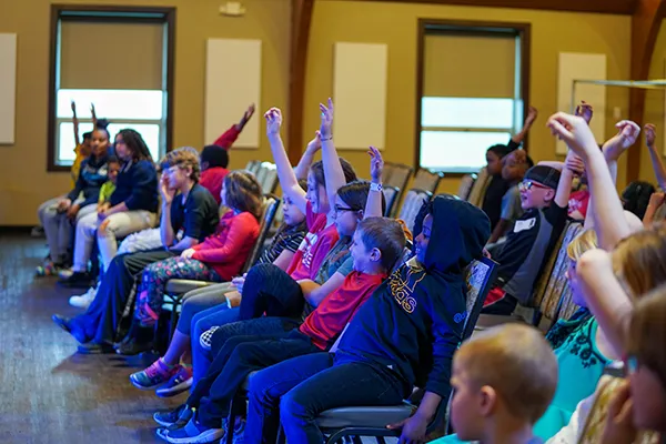 Photo of children  raising their hands at Reach Church