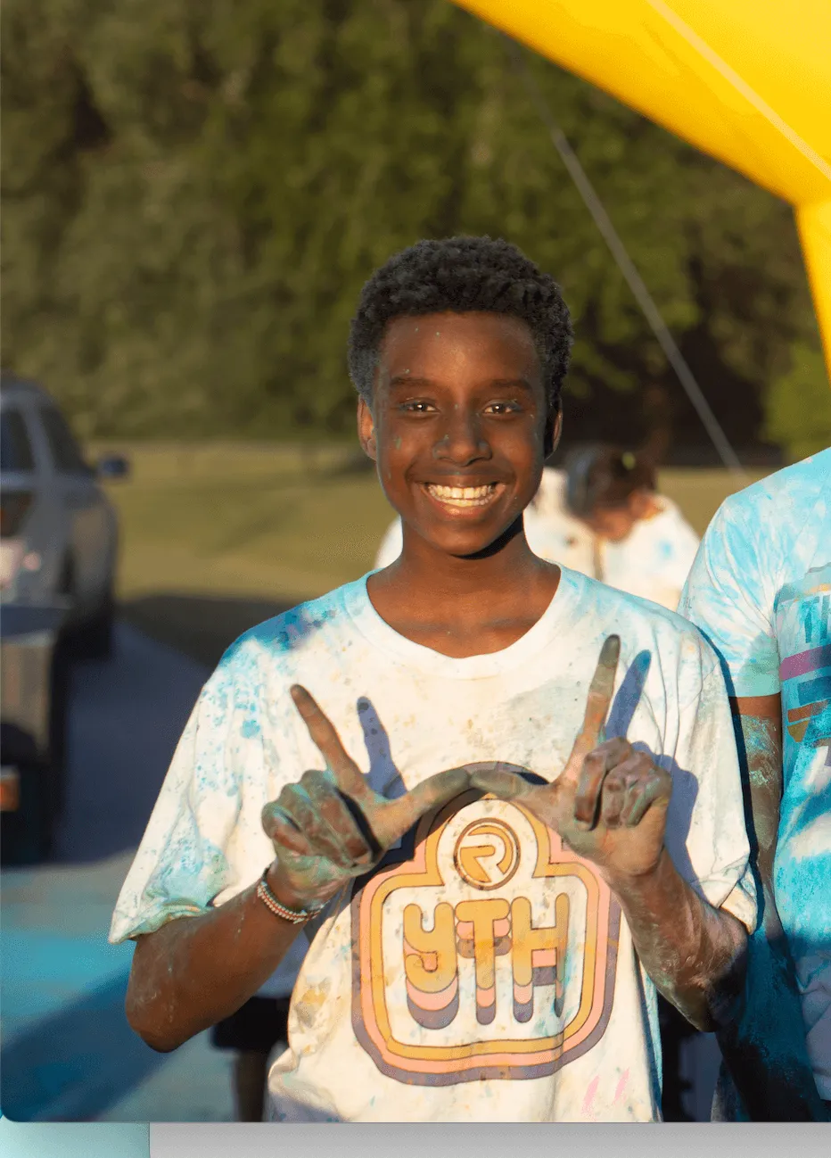 An image showcasing a young boy engaging in recreational activities, specifically playing in a pool, at Reach Church's event.
