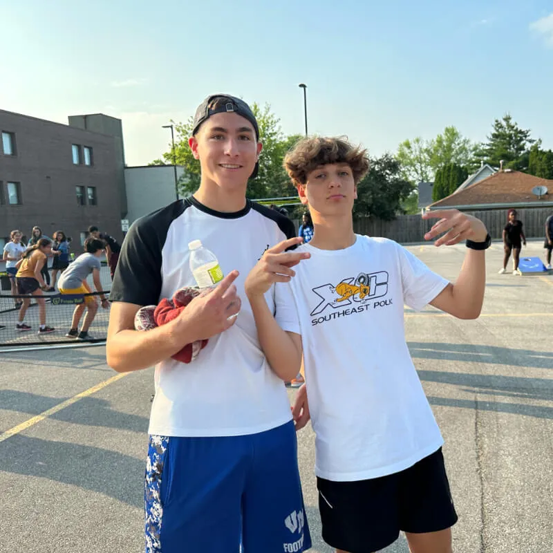 An image featuring two young boys, smiling and exhibiting a friendly demeanor towards each other, within the premises of Reach Church.