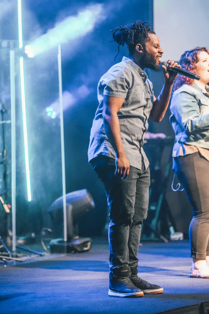 An image of people attending a live worship service at Reach Church