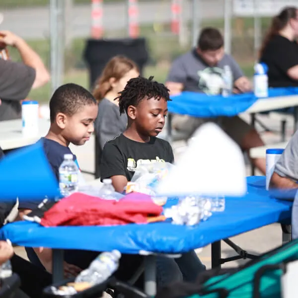 An image showcasing a young boy engaging in recreational activities, specifically playing in a pool, at Reach Church's event.