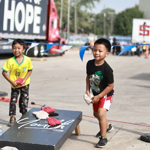 An image showcasing a young boy engaging in recreational activities, specifically playing in a pool, at Reach Church's event.