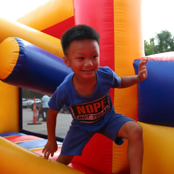 An image showcasing a young boy engaging in recreational activities, specifically playing in a pool, at Reach Church's event.