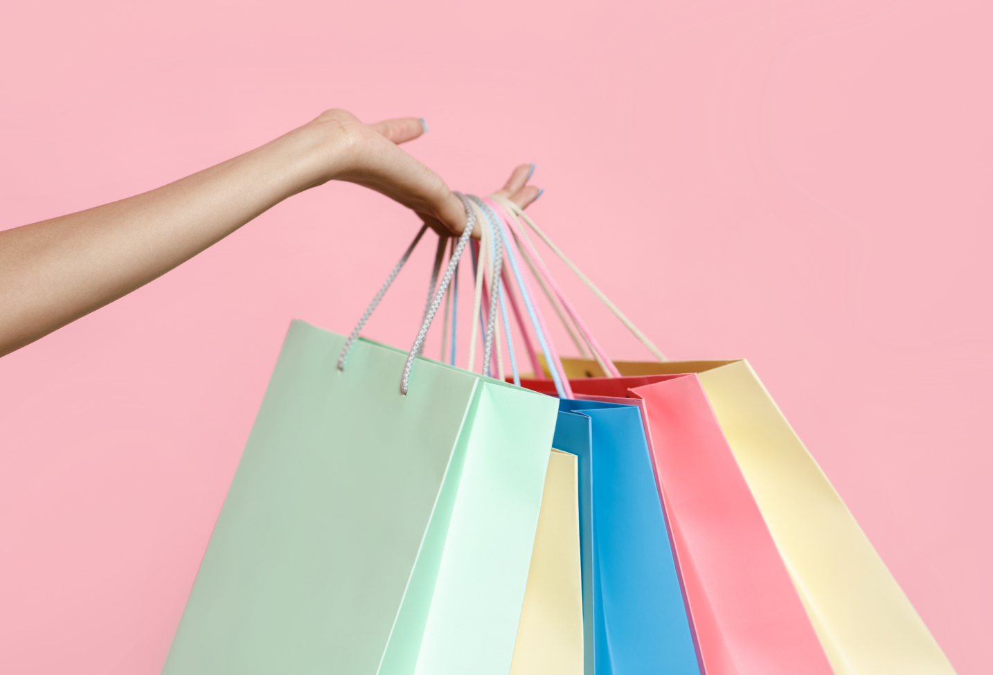 Hand holding multiple shopping bags