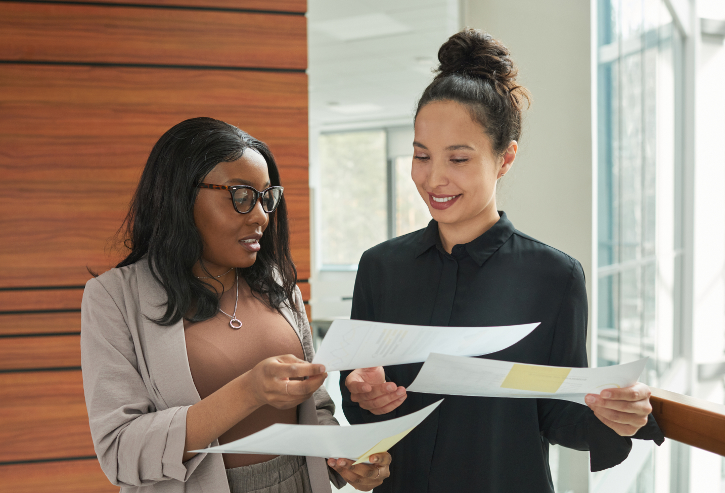 Two business women looking at report