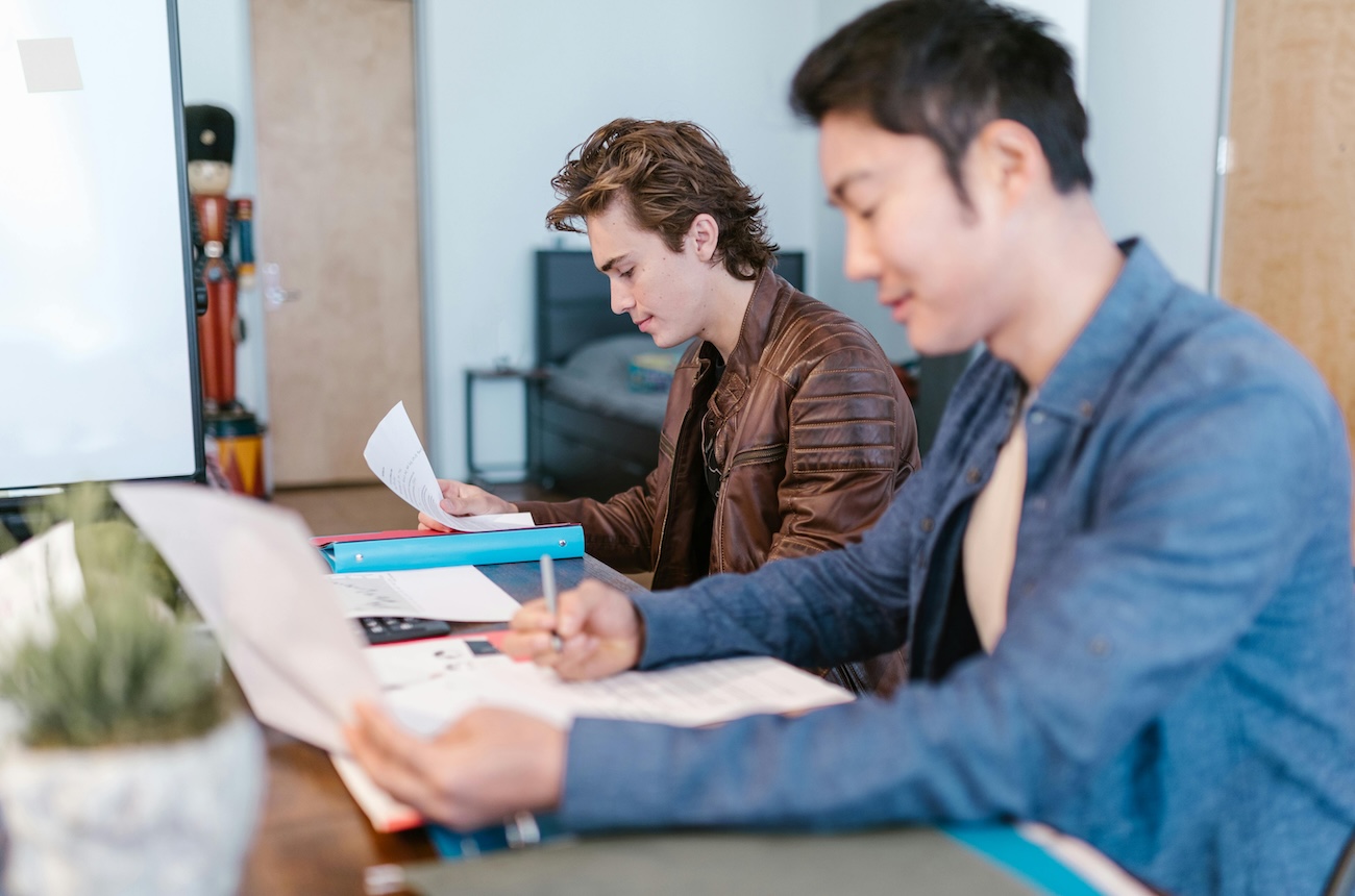 Two guys sitting next to each other at a desk