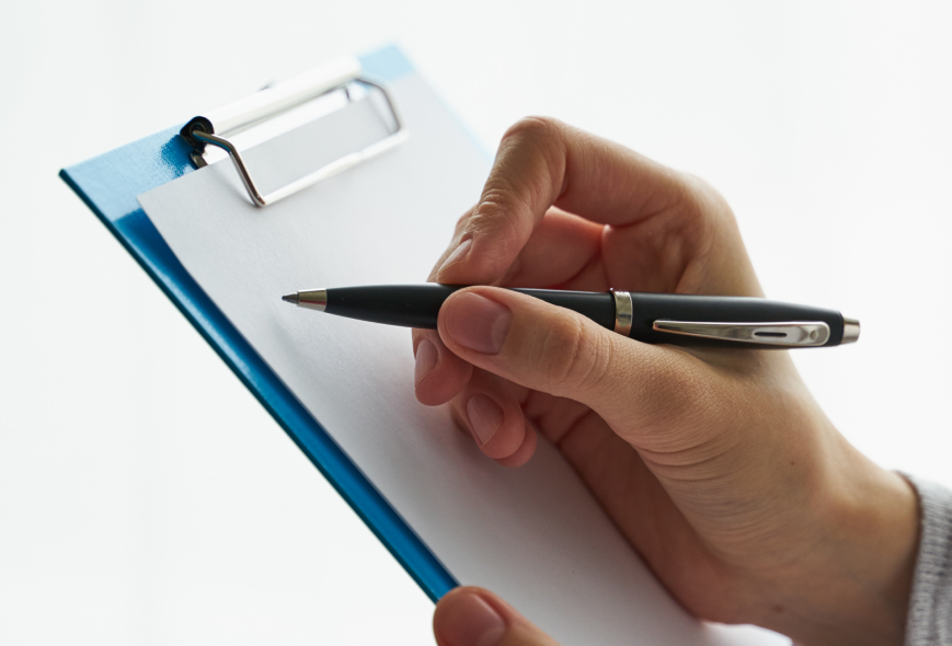 Hand checking boxes on a clipboard