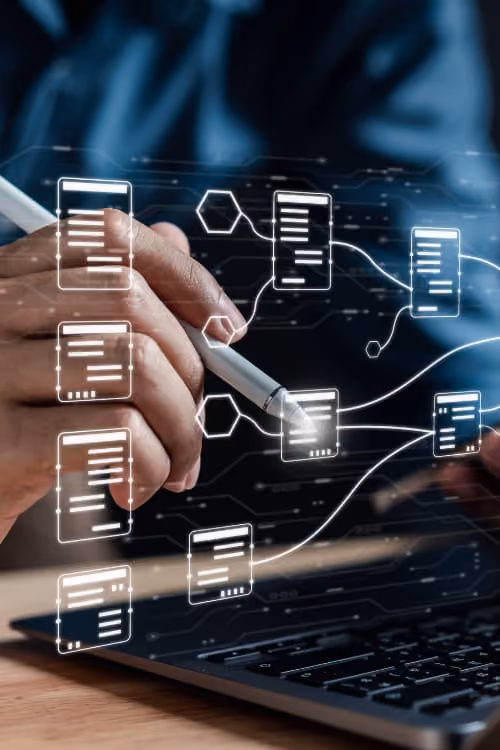 Person using a laptop, smartphone, and stylus, with digital data flows and document icons visualizing connected data processing.