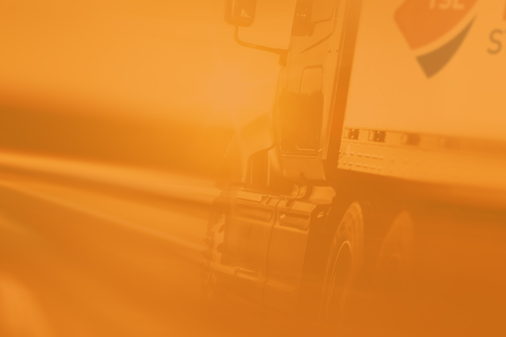 A blurred side view image of a truck with an orange coloured tint