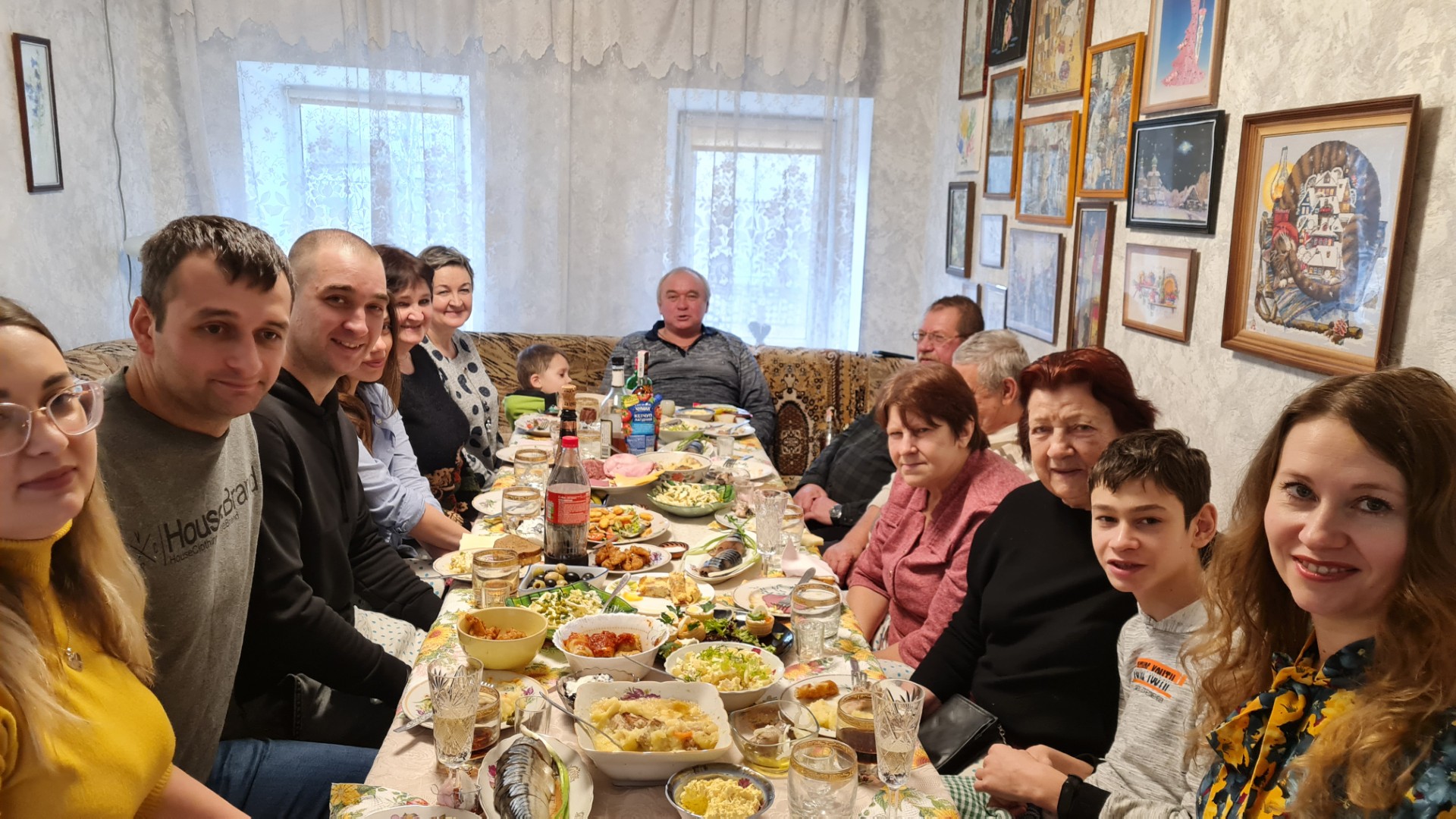 Volodymyr sitter ved en dekket middagsbord sammen med venner og familie.