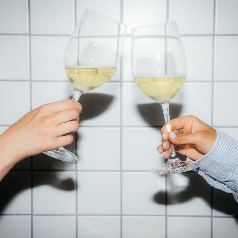 Two wine glasses cheersing 