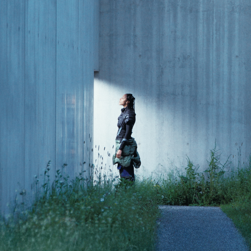 In VIADI by moving mountains image with woman standing in the light infront of a wall.