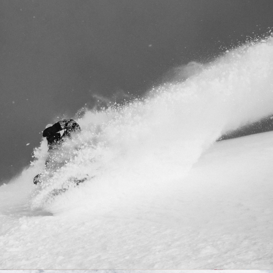 Powder turn by a snowboarder