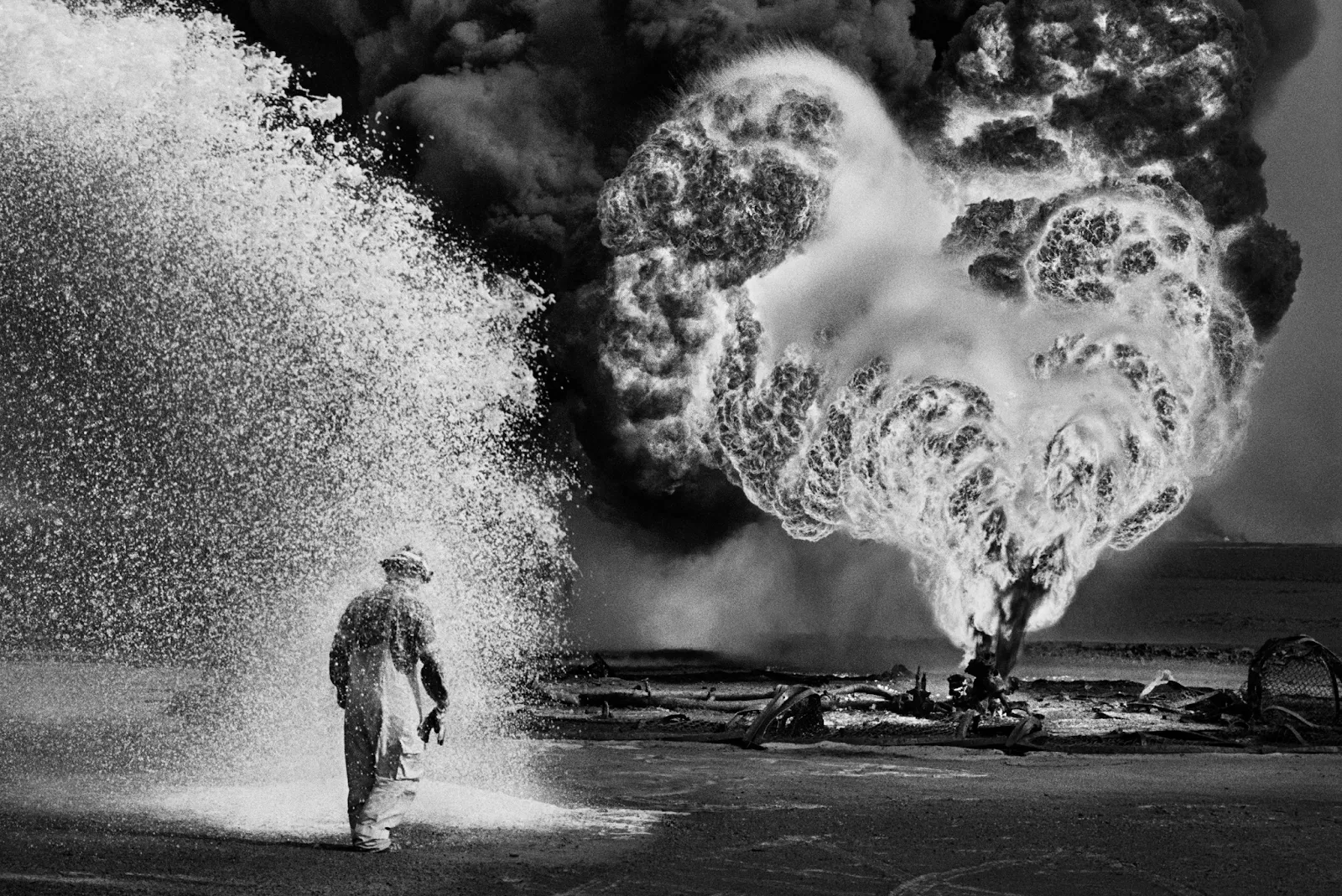 Campo Petrolífero de Greater Burhan, Kuwait, 1991 Spray químico protege bombeiro. Imagem: Sebastião Salgado.‍
