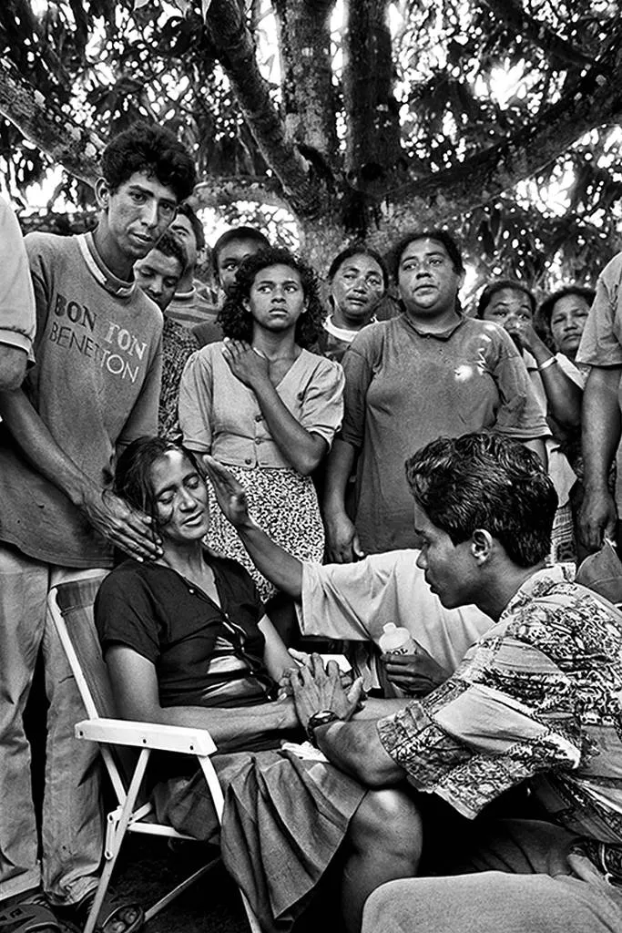 Mulher sendo confortada por seus familiares durante a cerimônia fúnebre. Imagem: Sebastião Salgado.