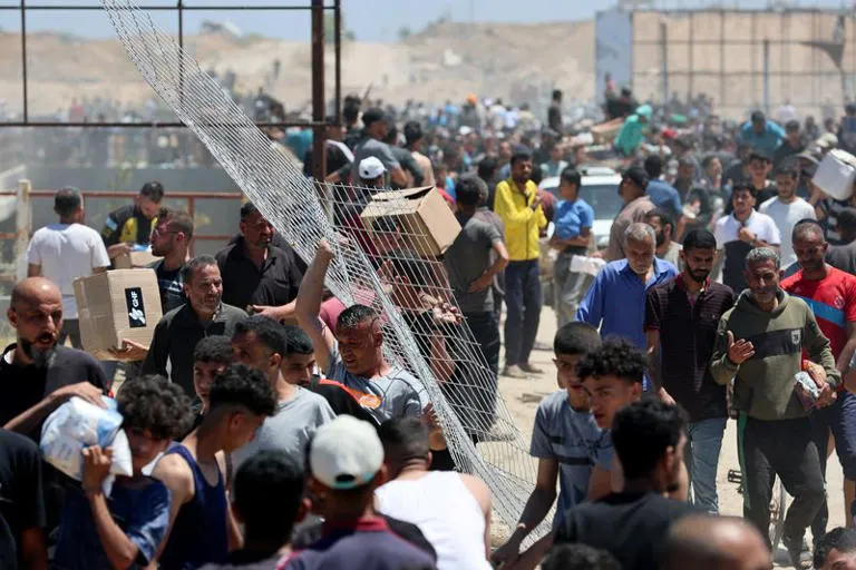 Palestinos recebem suprimentos de ajuda da Fundação Humanitária de Gaza. Imagem: REUTERS/Ramadan Abed.