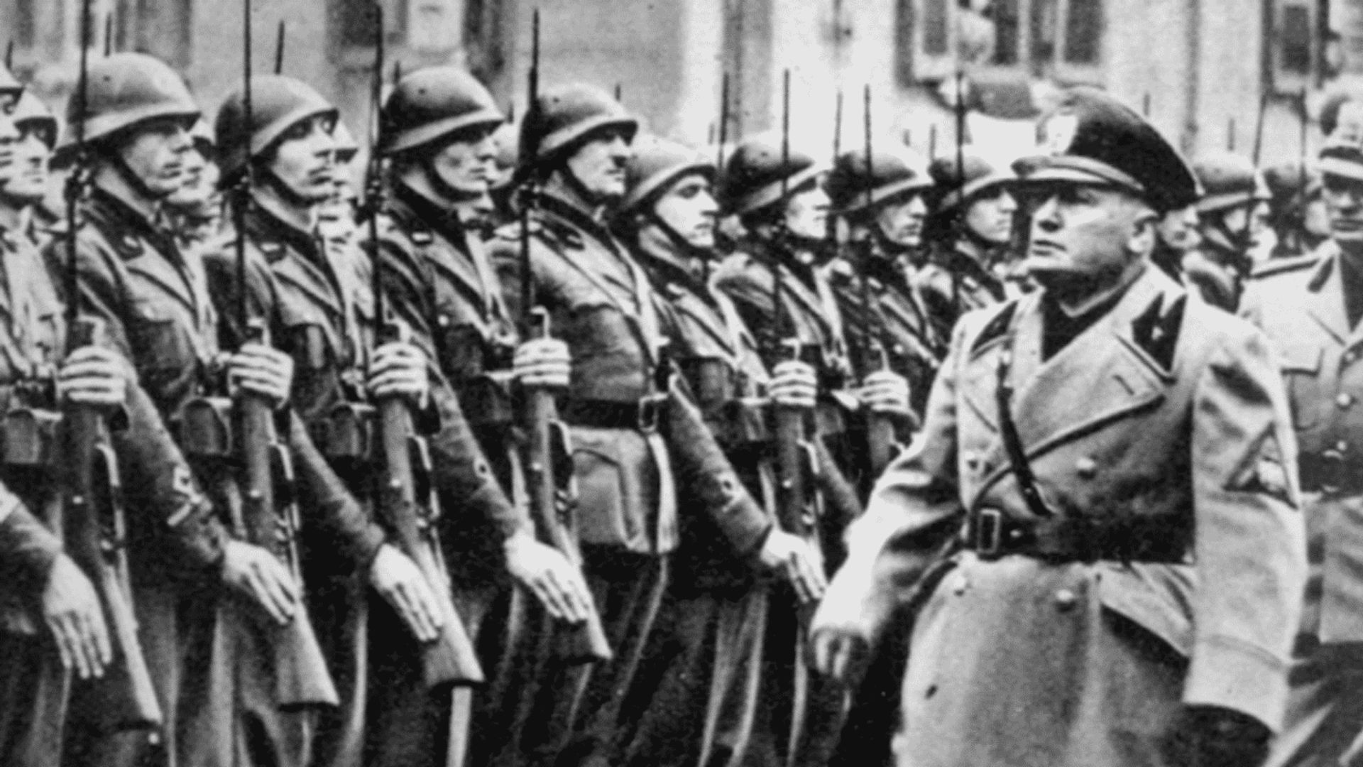 Benito Mussolini, o criador do fascismo, passando em revista a tropas do exército italiano.