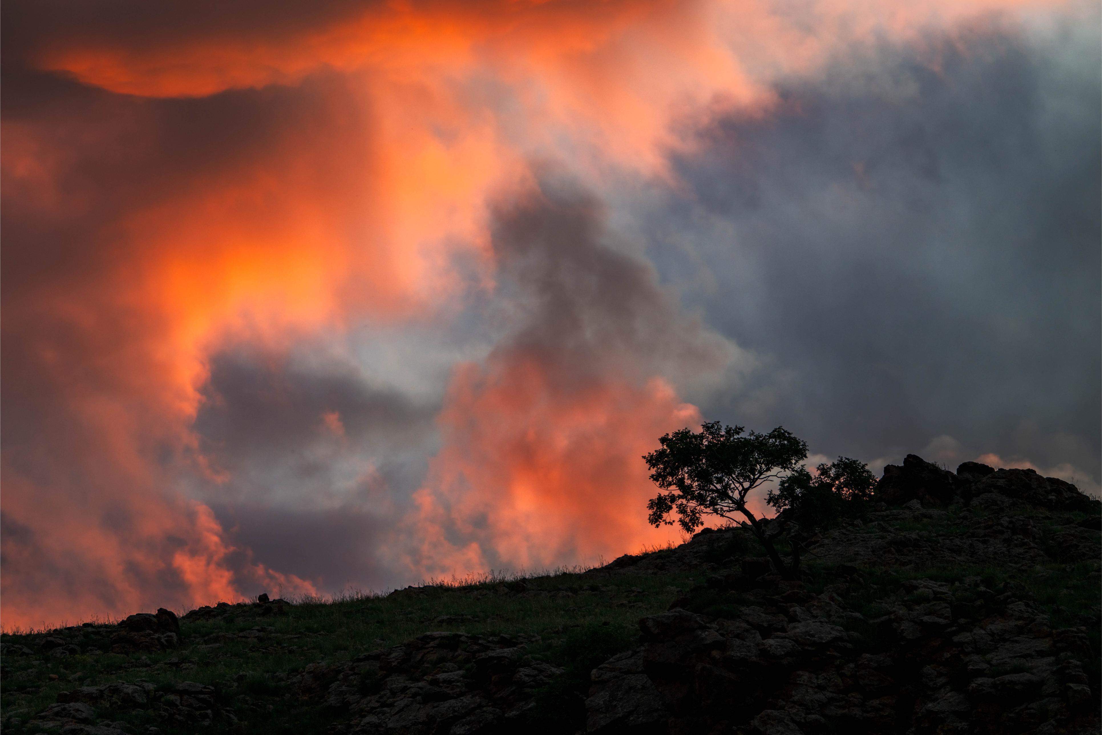 Orange clouds at sunset with a black sky in the background