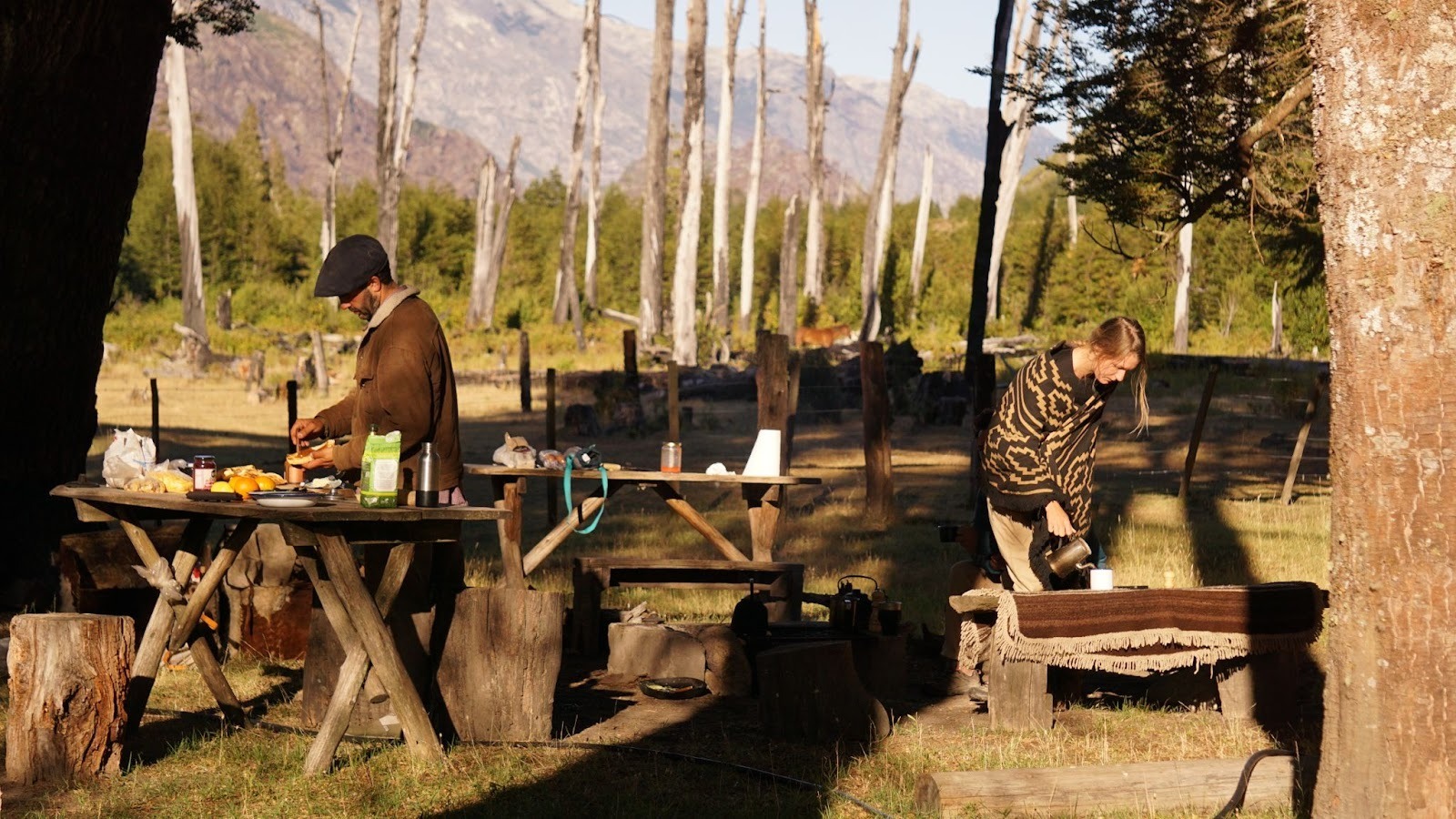 Gauchos making breakfast as the sun comes up in the forest