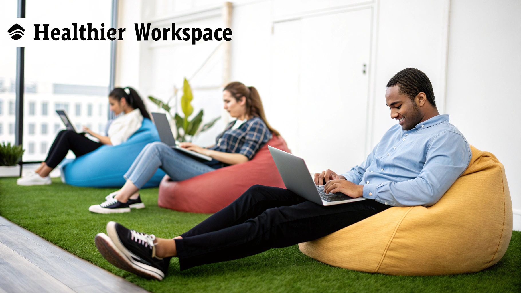 Three young professionals comfortably work on laptops, seated on colorful bean bags in a modern office.