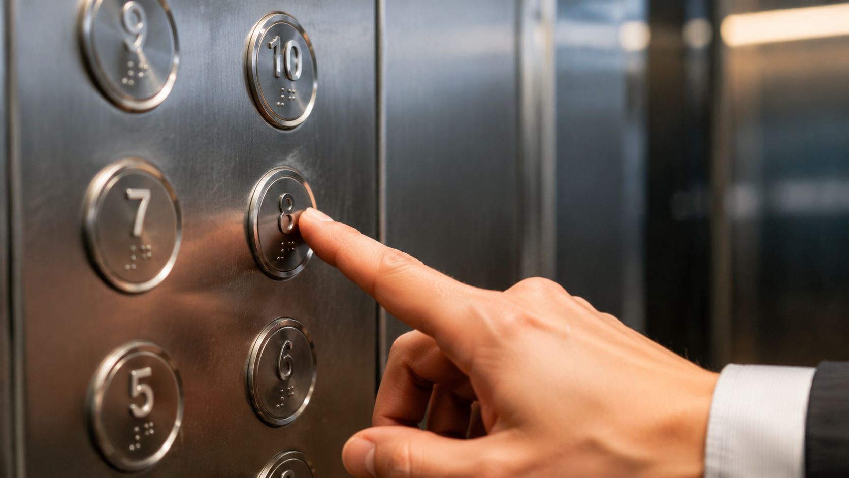 A close-up shot of a person's finger pressing the number eight button inside an office elevator.