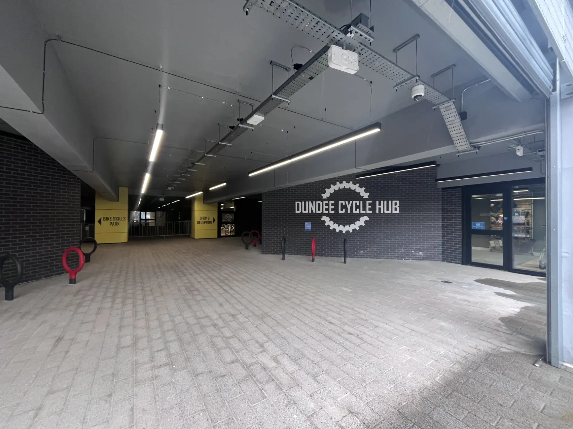 Entrance to Dundee Cycle Hub, with signs for the bike skills park and shop & reception in the background