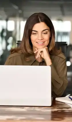 Business professional working at a desk with documents and a laptop.