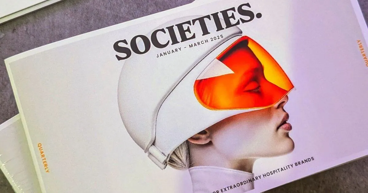 Magazine cover titled SOCIETIES January-March 2025 featuring a profile of a person wearing a white helmet with an orange visor.