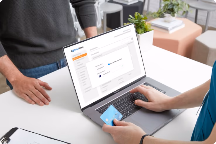 Small business owner typing credit card information into a laptop
