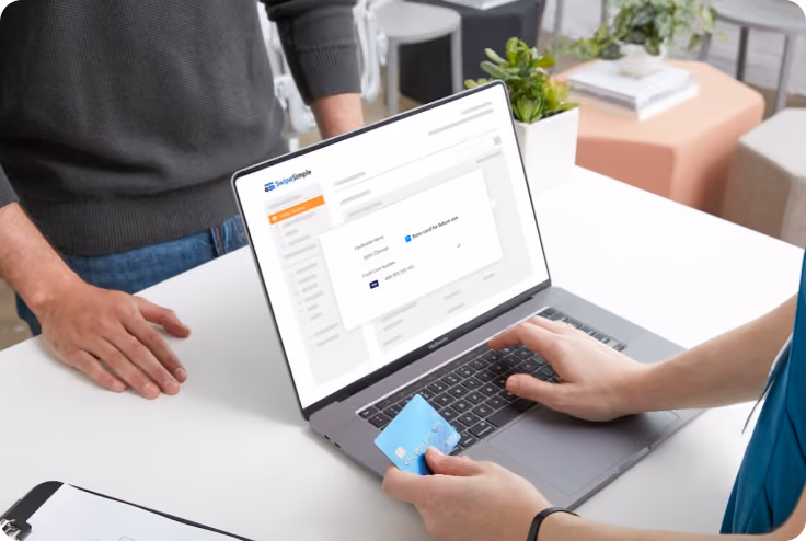 Small business owner typing credit card information into their laptop computer using SwipeSimple 
