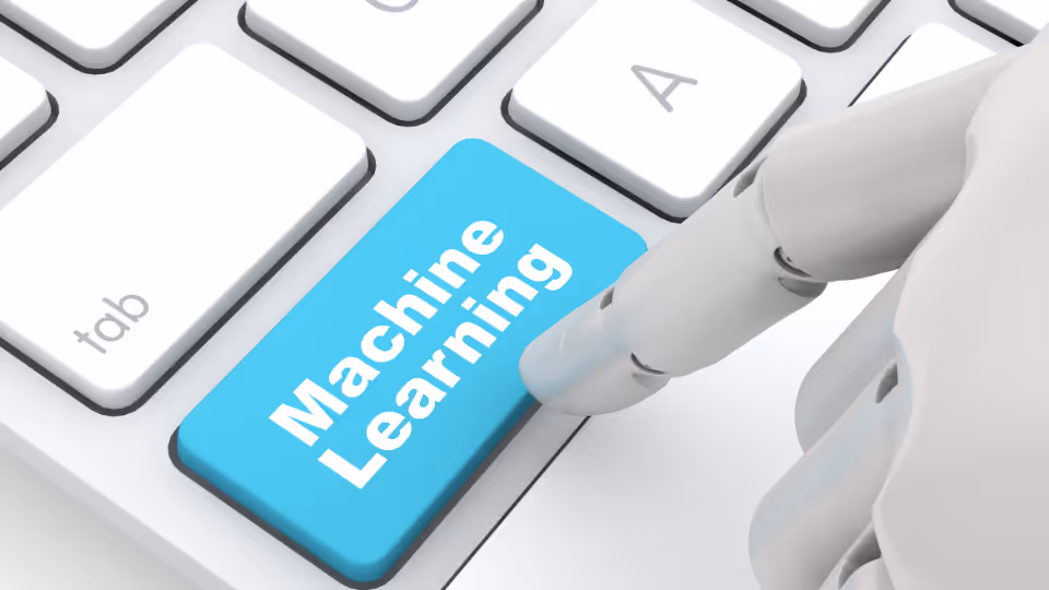 Alt text: A robot hand pressing a button that says "Machine Learning" on a keyboard