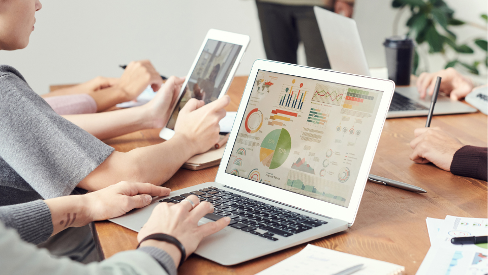 Alt text: A group of people sitting around a table with laptops