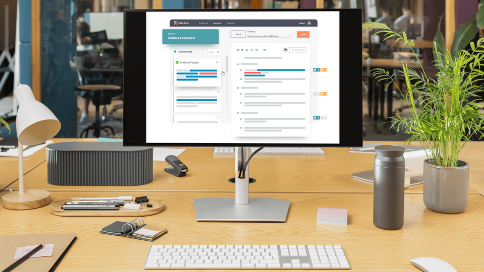 Alt text: The DocJuris interface displayed on a desktop computer, set on a desk with a plant, keyboard, water bottle, and lamp arranged neatly around it