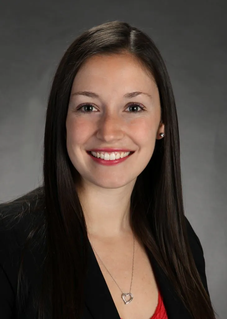 A woman in a black jacket smiling at the camera