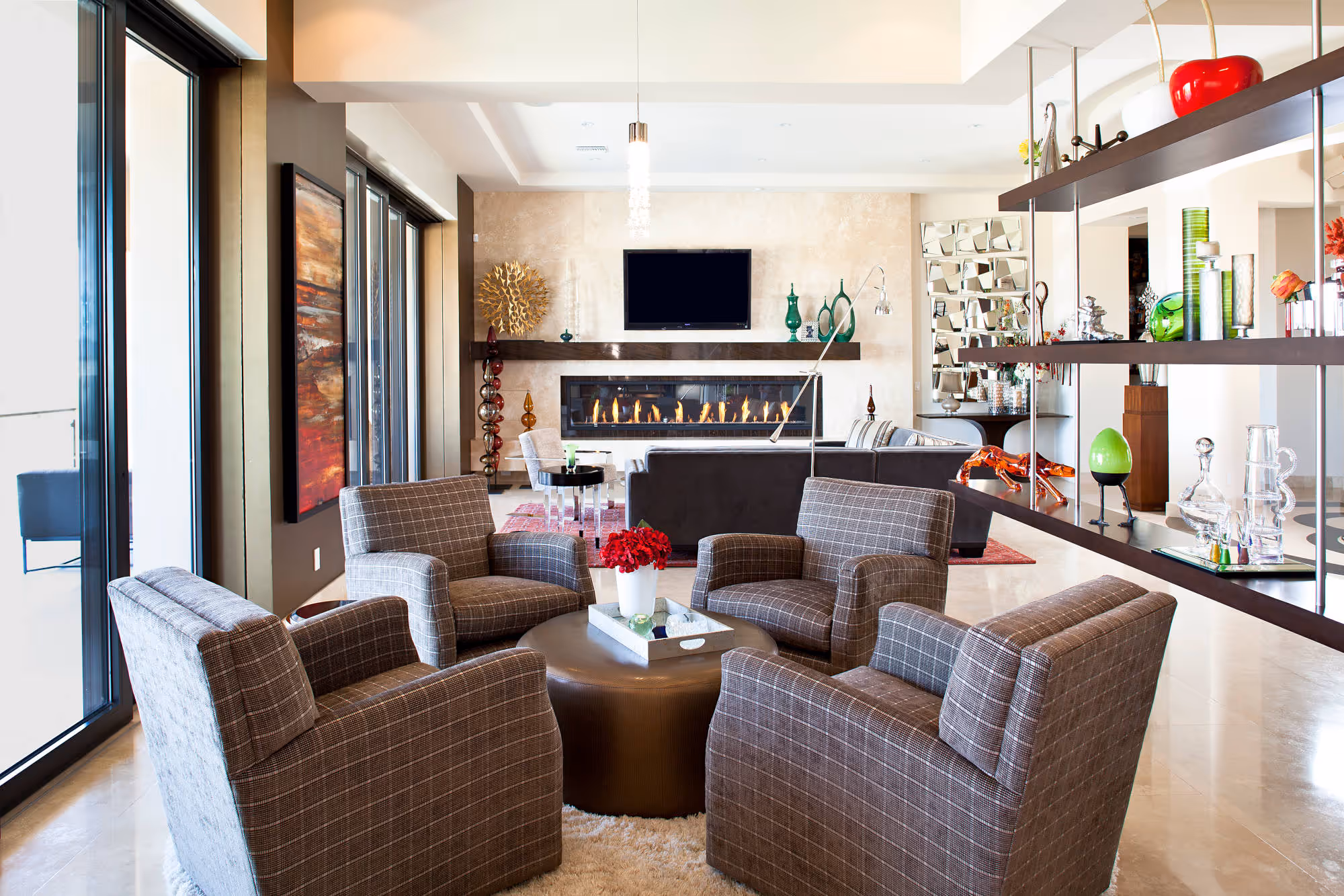 Family room with contomparary swivel chairs, suspended dark wood shelves, large window sliders.