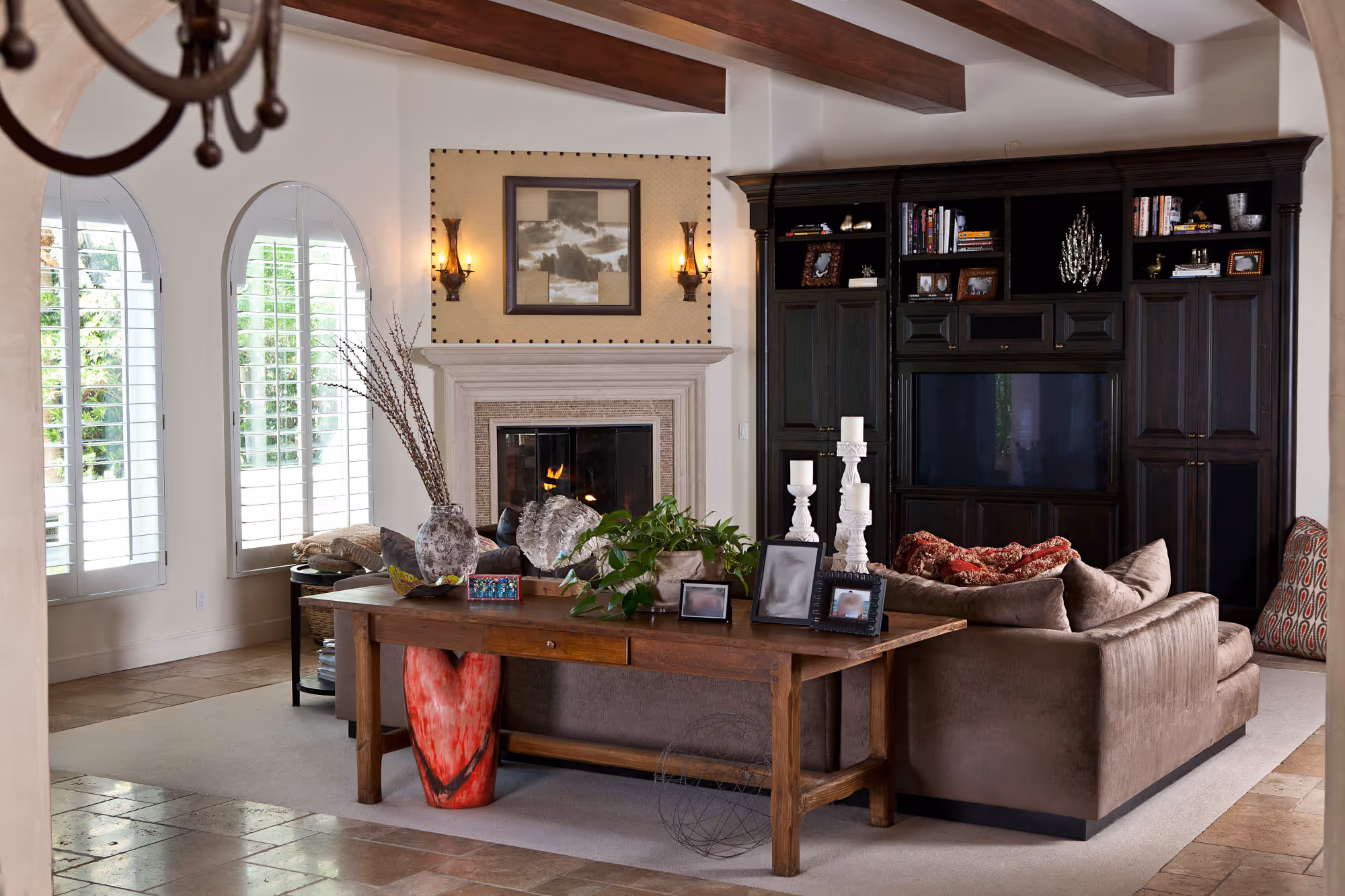 Spanish style family room with wood beams and custom stone fireplace.