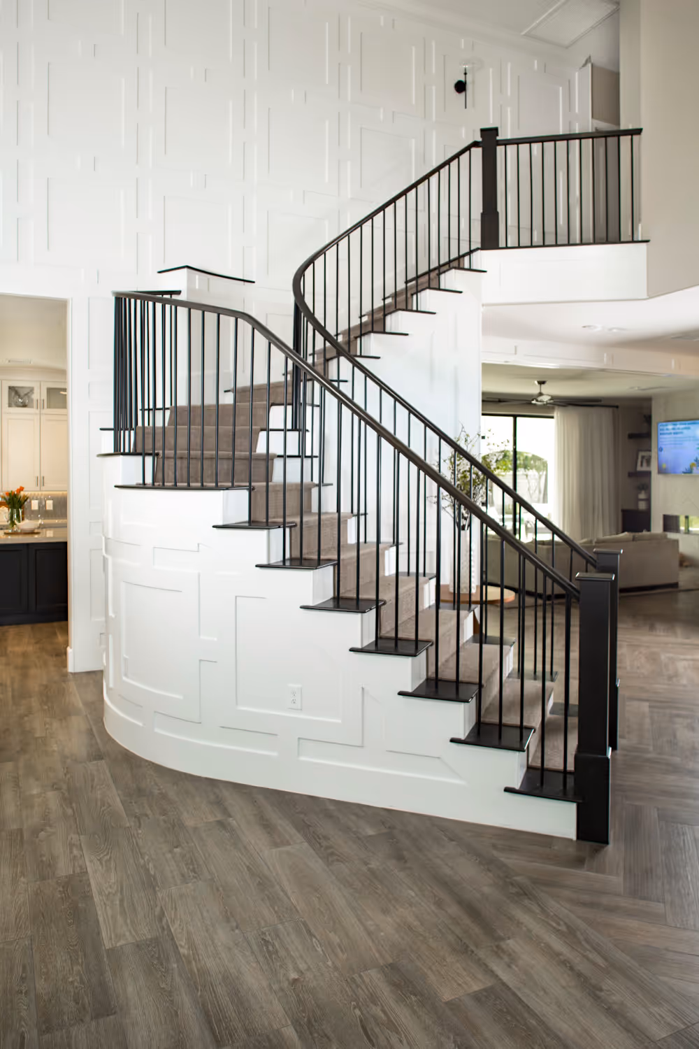 Staircase and wall with white wood panelling, dark wood railing and dark wood stair steps. 