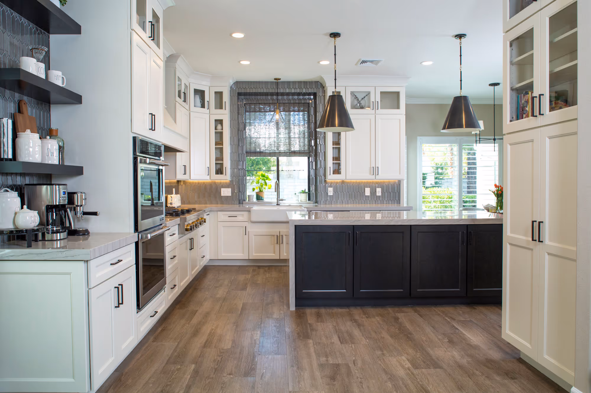 White kitchen, gray glass backsplash, espresso island cabinets, bronze pendents, title wood floor.
