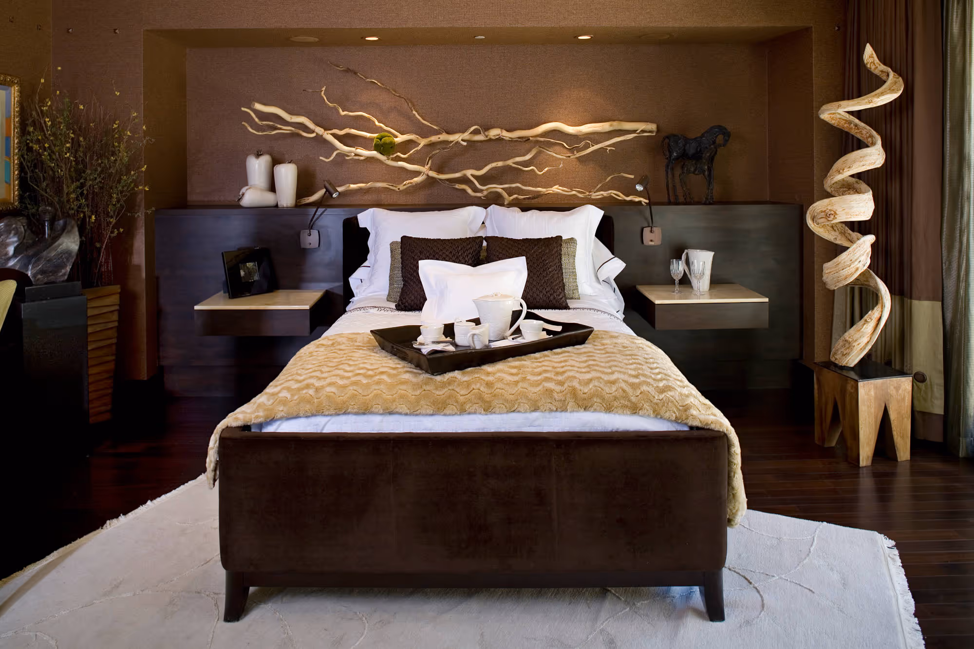 Contemporary bedroom with grass cloth wallpaper, organic wood sculpture and floating nightstands.