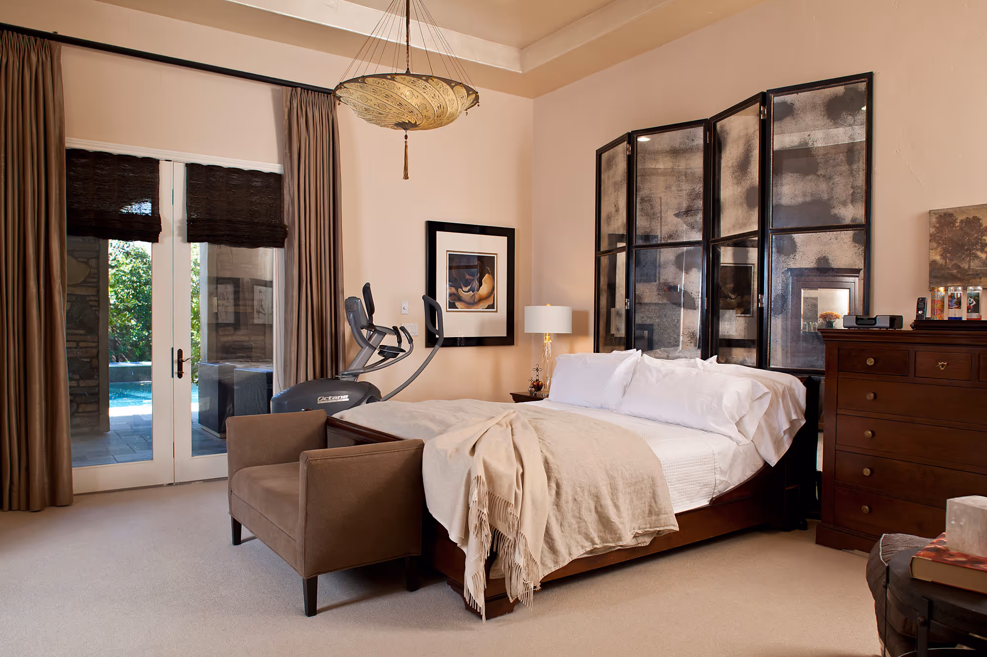 Spanish styled master bedroom with antique mirror headboard screen.
