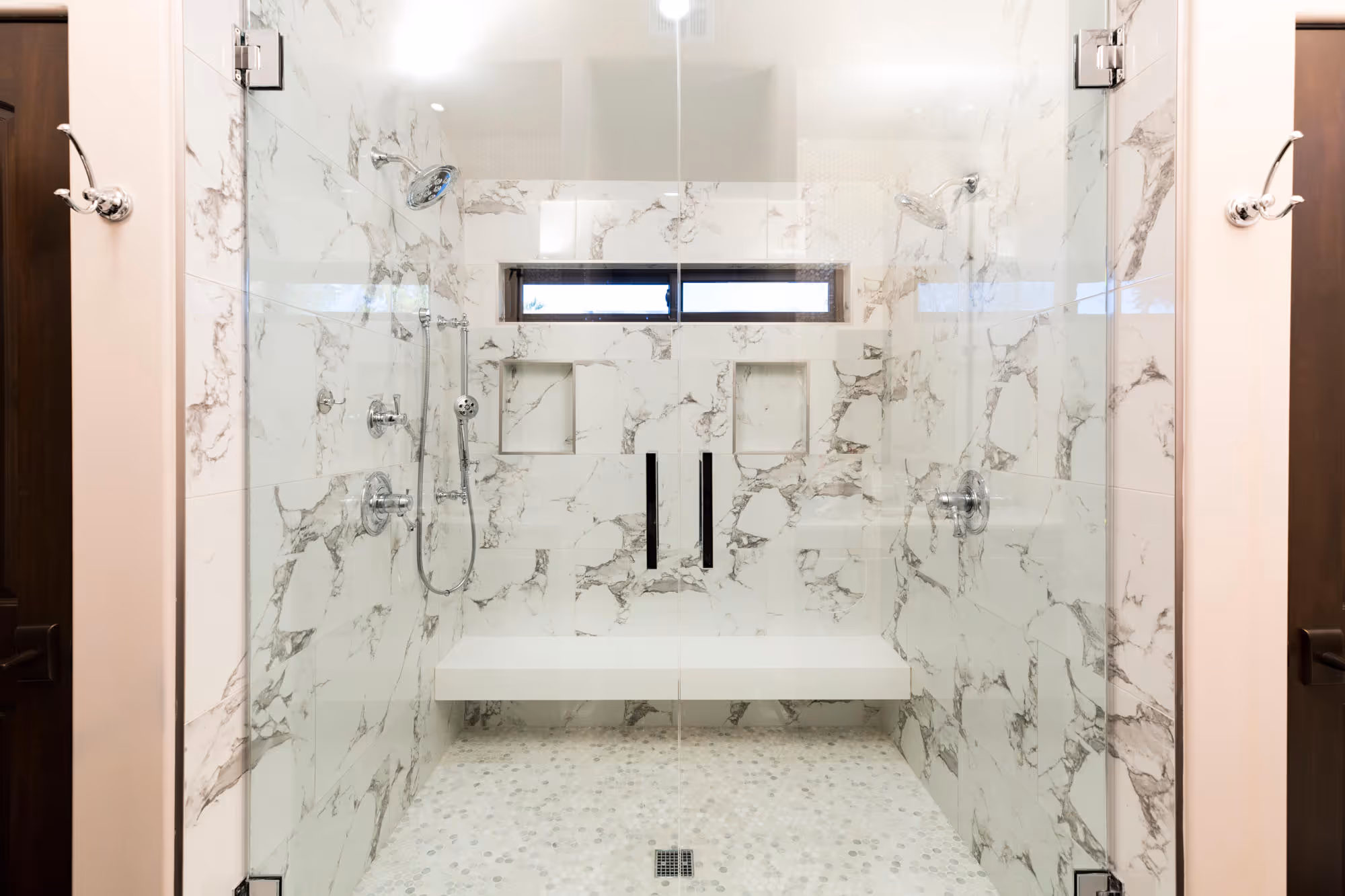Master bath walk-in shower with white marble and chrome accents.