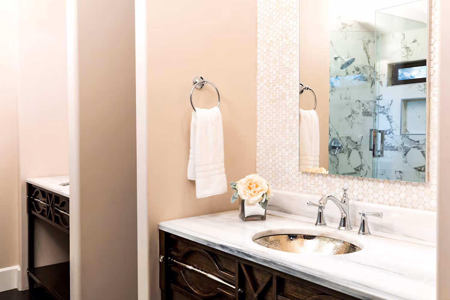 Master bath with wood and silver vanity cabinet, Marble top, silver metal sink.