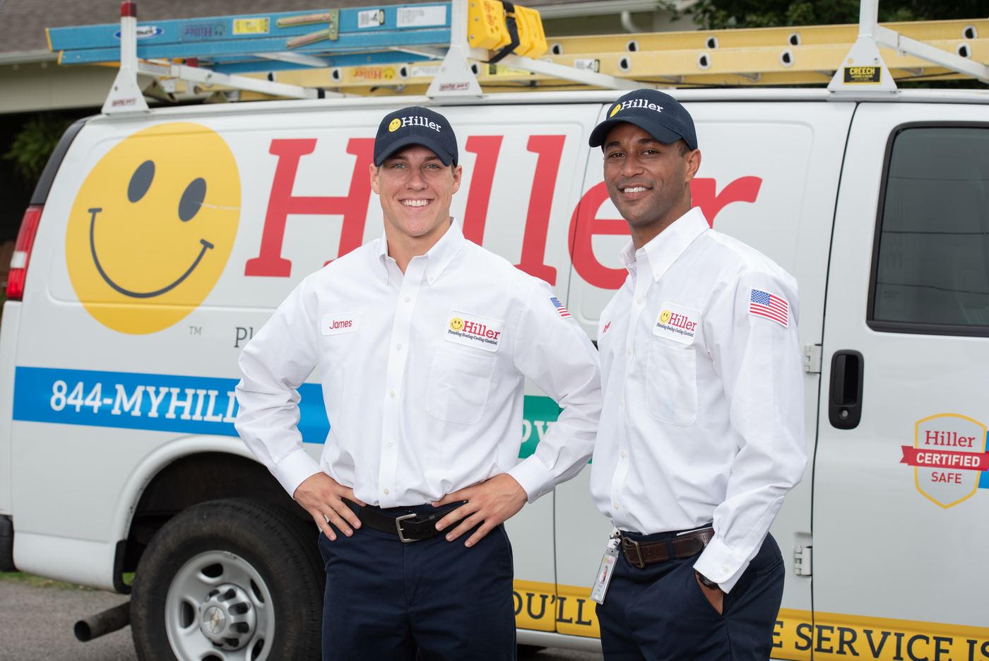 Two Hiller technicians in front of a Happy Face truck