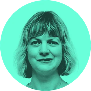 A woman with shoulder-length blonde hair smiles against a vibrant turquoise background in a circular frame.