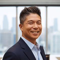 Smiling man in business suit with city skyline in the background.