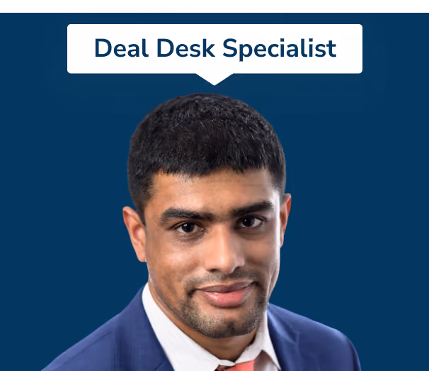 Portrait of a man with short black hair wearing a blue suit, white shirt, and light red tie, with a label above him reading 'Deal Desk Specialist' on a dark blue background.