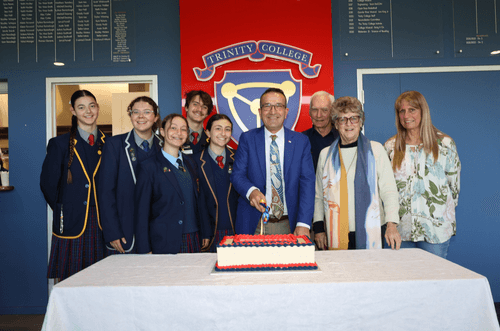 Local MP Tony Piccolo about to cut the volunteer celebration cake while (from left) student volunteers Ella Handke, Luana Murray, Chiara Puccini, Connor Foreman, and Daniella Puccini, Tony Piccolo MP, and community volunteers Dave Clarke, Jan Arnott and Jane Fraser.